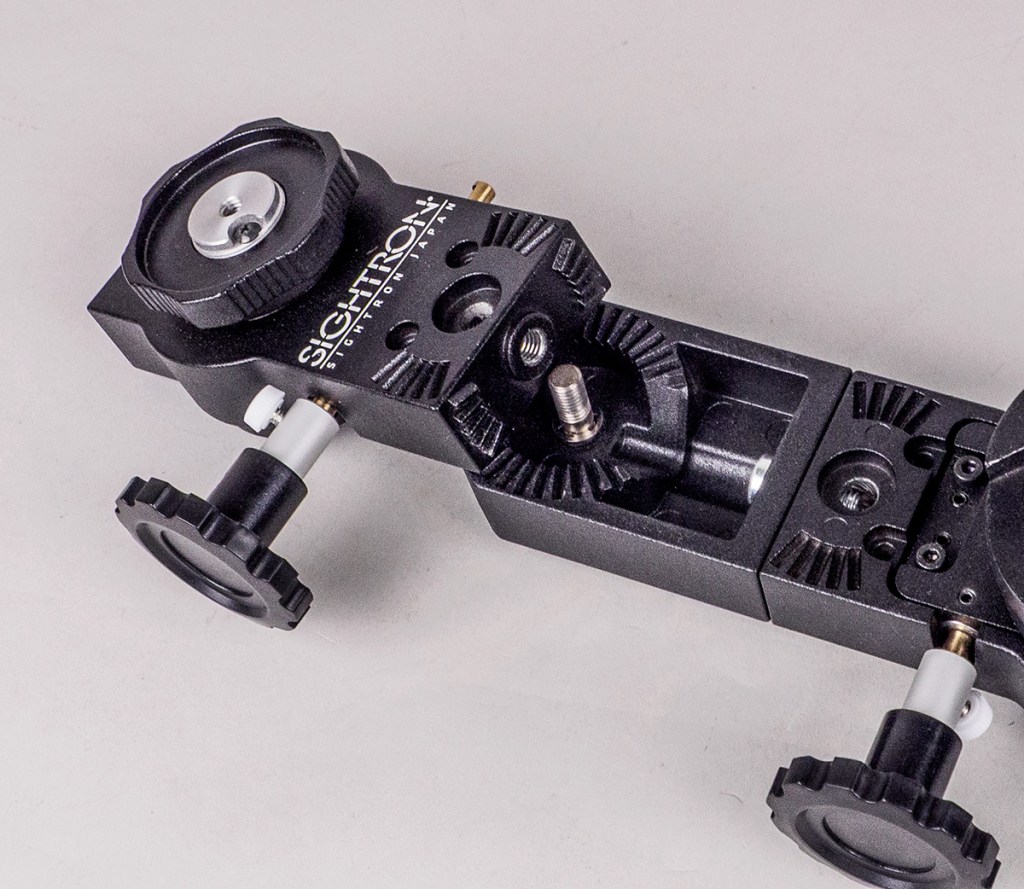 Close-up view of a Sightron mounting bracket featuring dials and adjustment knobs, designed for precision equipment.